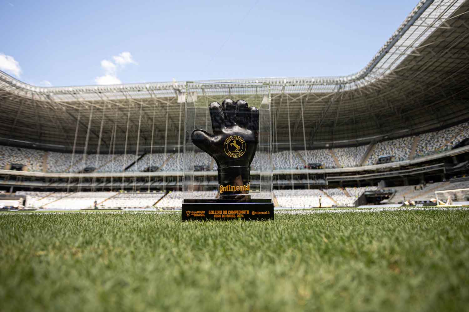 (Troféu de melhor goleiro da Copa do Brasil 2024, feito de borracha de pneu Continental, exibido no gramado de estádio vazio)